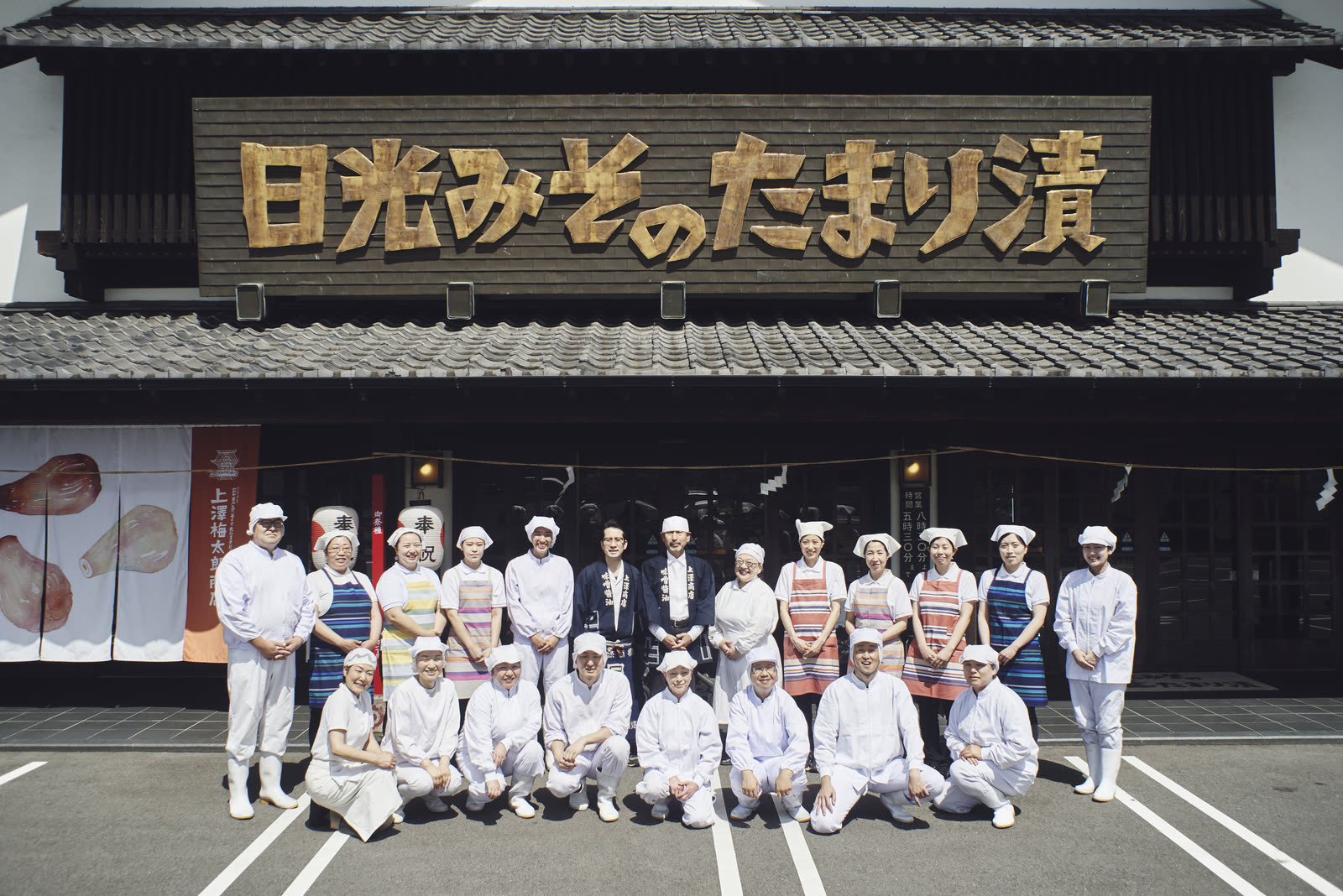 上澤梅太郎商店の店舗前で並ぶ従業員一同
